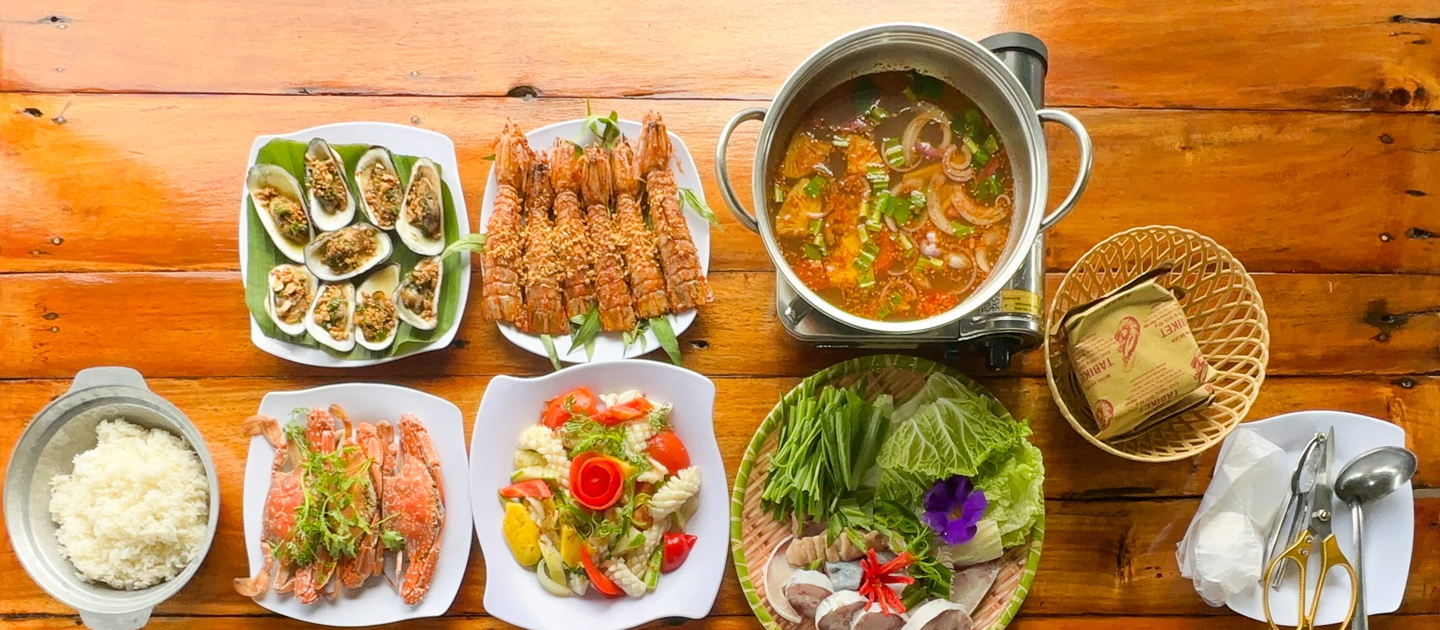 The combo seafood set for three guests: Grilled shellfish, garlic mantis shrimp, steamed crab, sweet-and-sour squid, cobia hotpot and steamed rice