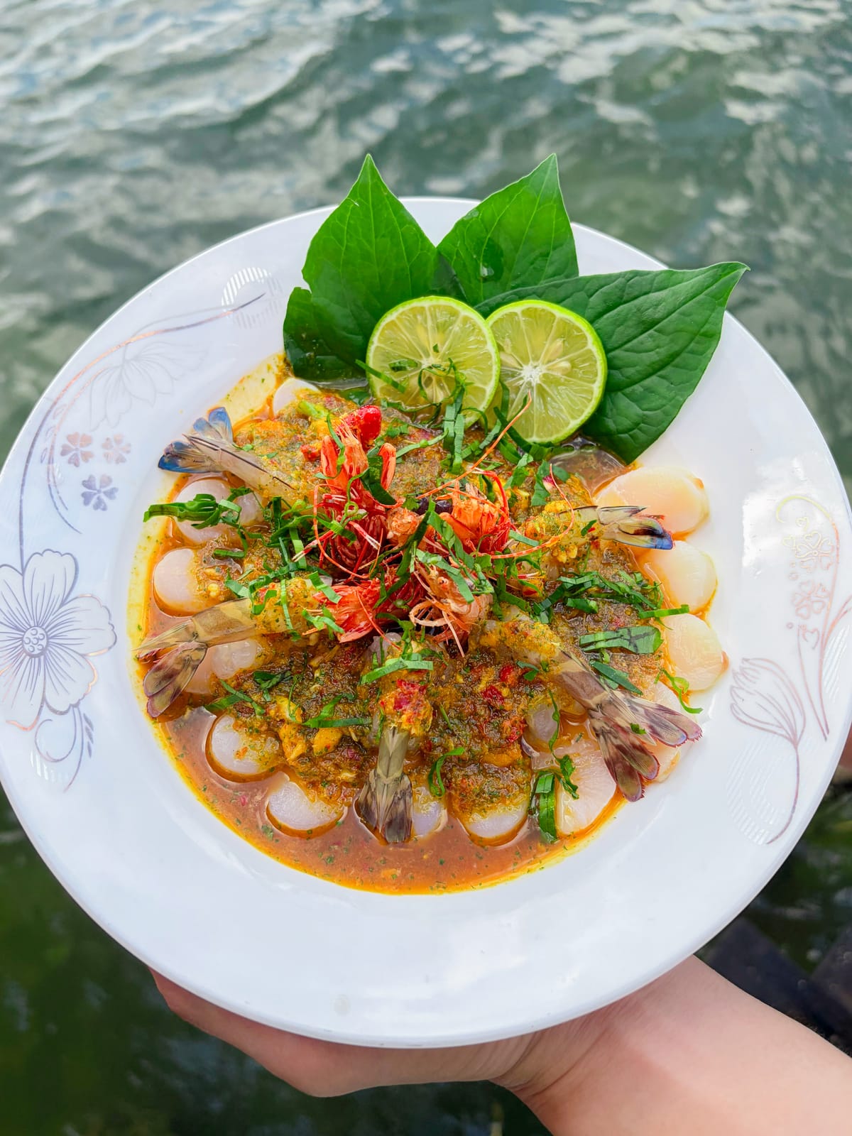 Đĩa tôm sốt Thái bày cho một người trước khung cảnh biển